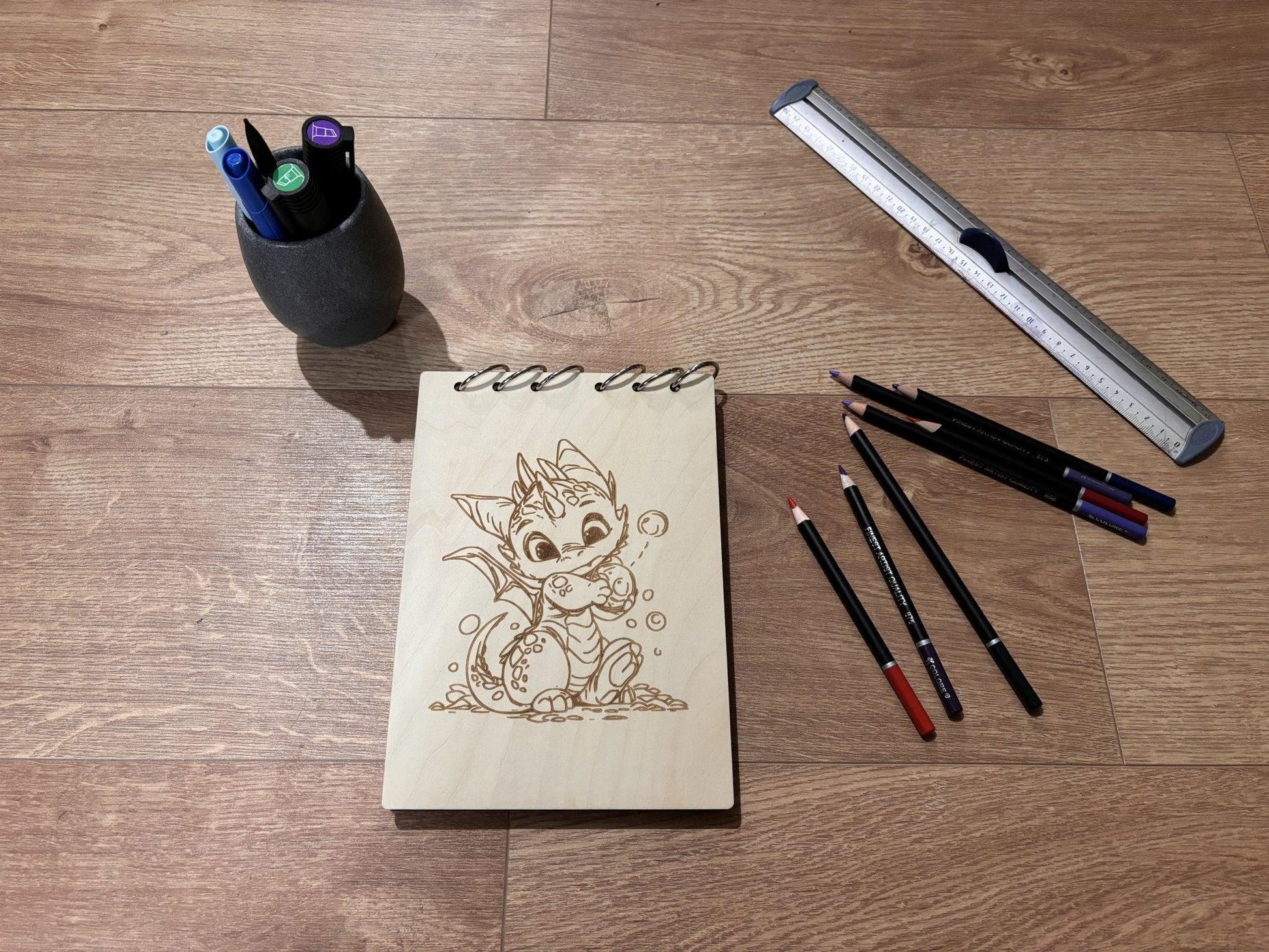 Bloc note  A5 avec crayon dragon avec une bulle dans les mains graver au laser rechargeable et ecologique fabrication francaise et artisanalebois